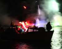 Santa sails past lit by fireworks